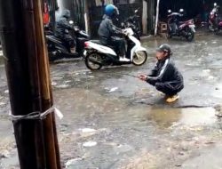 Kecewa Jalan Rusak, Warga Cicalengka Mancing di Kubangan Air di Jalan yang Berlubang
