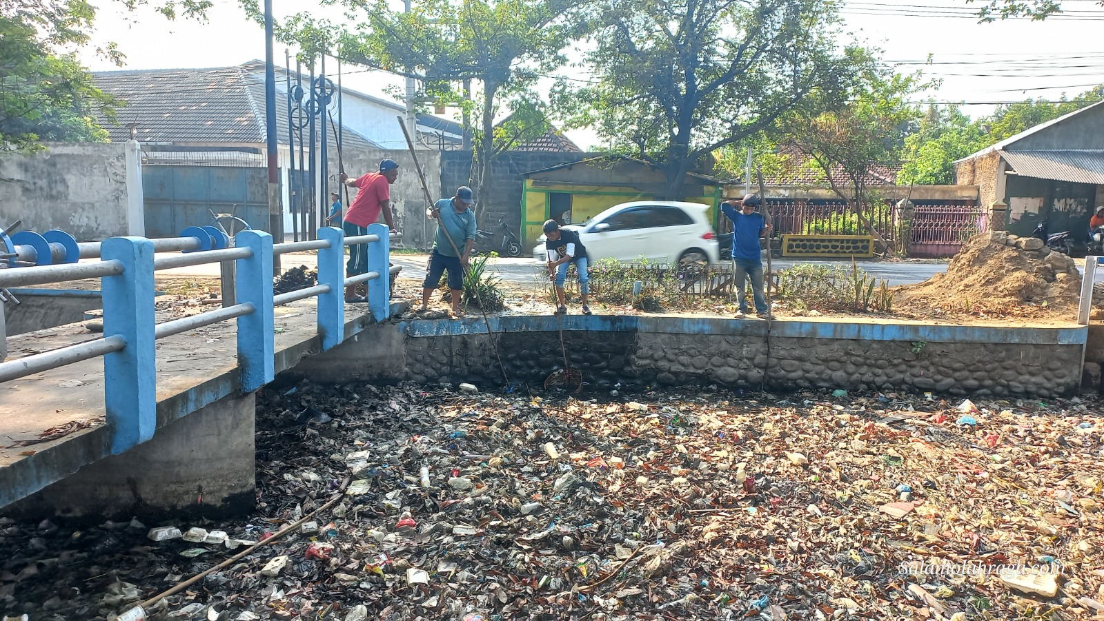Foto: Pasukan Satgas Jogo Kali berusaha mengangkat sampah dan endapan daun yang mencemari Kali Gude Mojokrapak.
