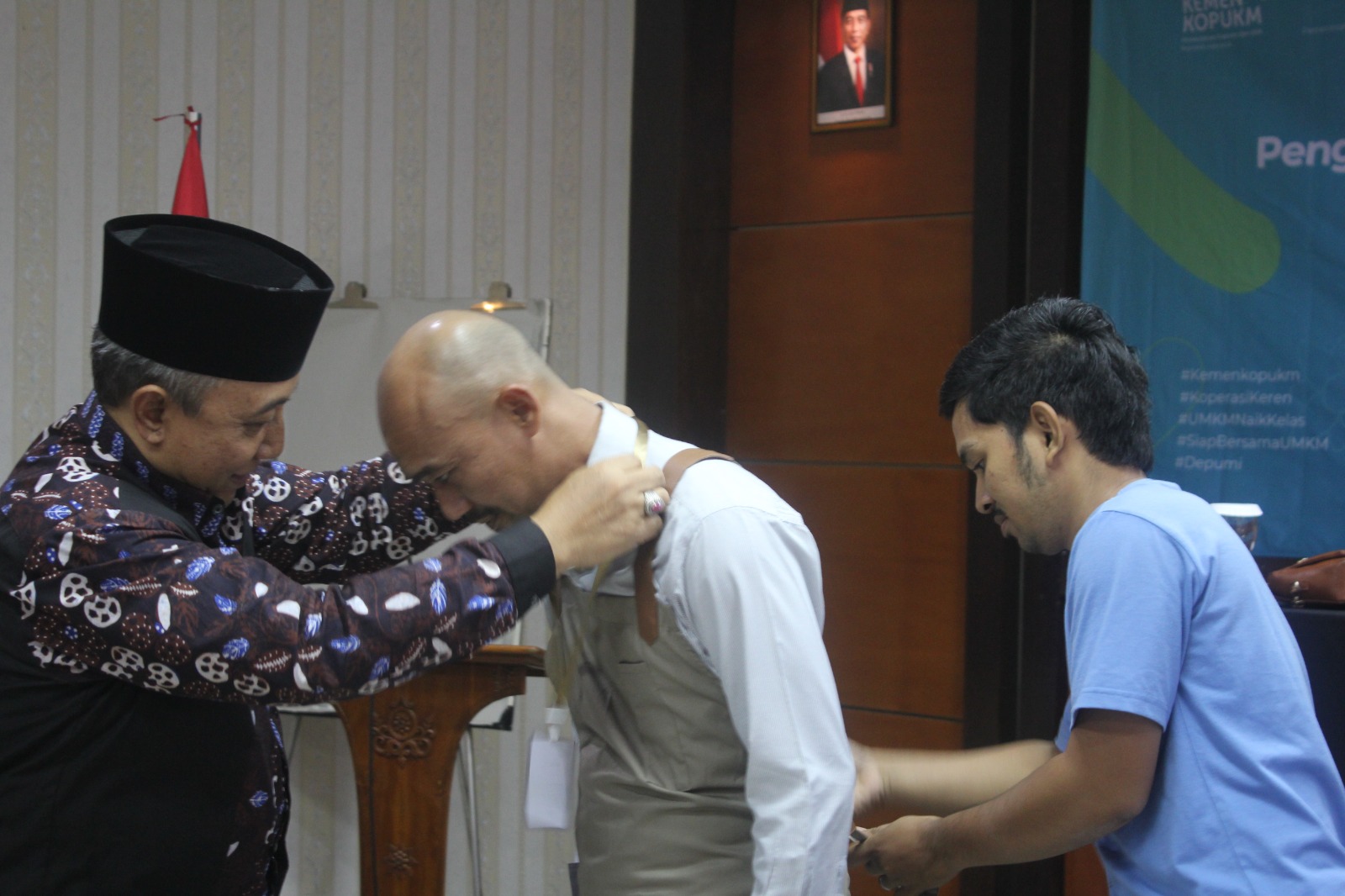 Foto: Pemakaian Apron pada perwakilan peserta sebagai tanda Program Peningkatan SDM dan Kompetensi Barista telah dibuka dan dimulai.