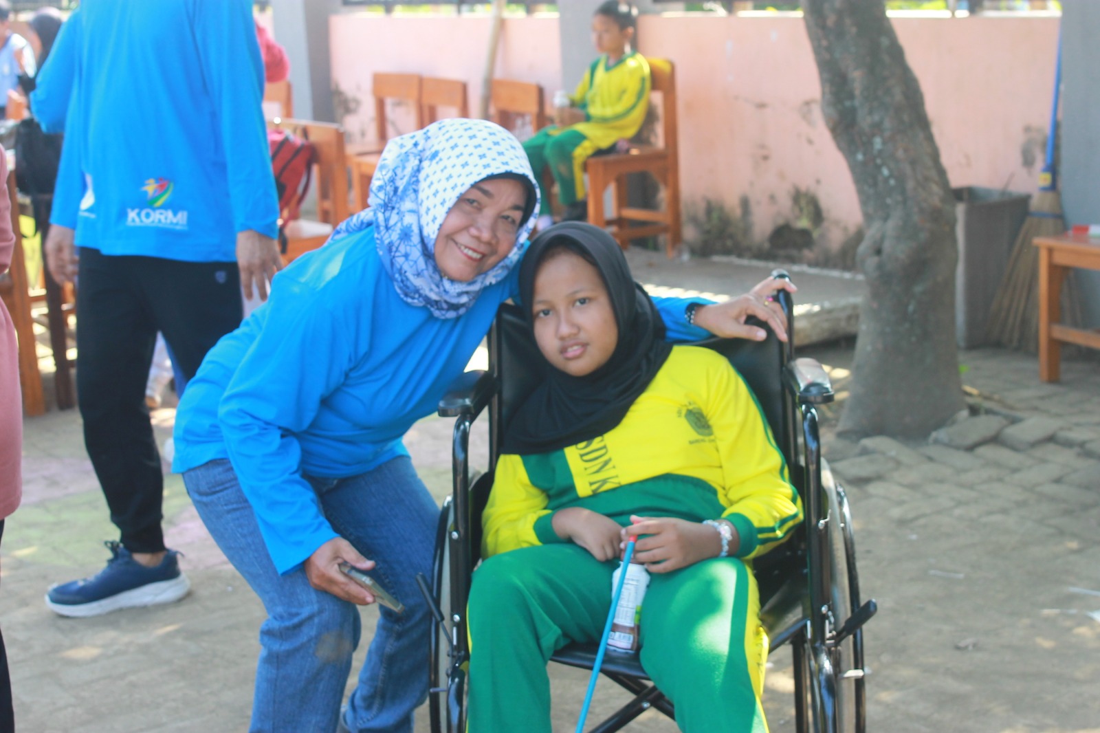 Foto: Bu Wati Bendahara KORMI Jombang bersama siswa difabel (inklusi) saat minum susu bersama di SDN Karangan 2 Bareng dan seketika itu mengajukan bantuan kursi roda ke Dinas Kesehatan Jombang.