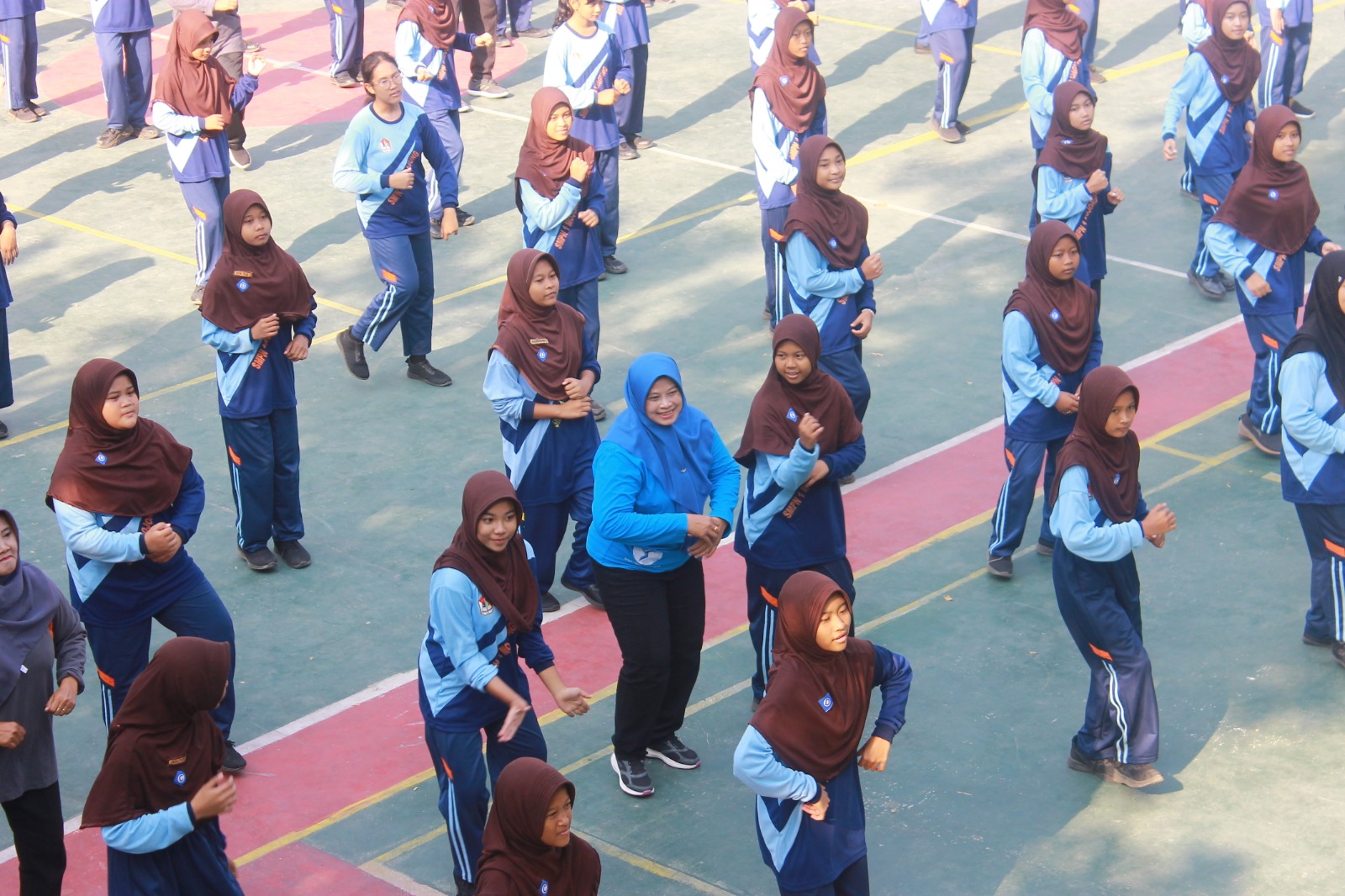 Foto: Keceriaan Wiwin Sumrambah, S.Pt. bersama siswa SMPN 1 Mojoagung saat senam bersama.