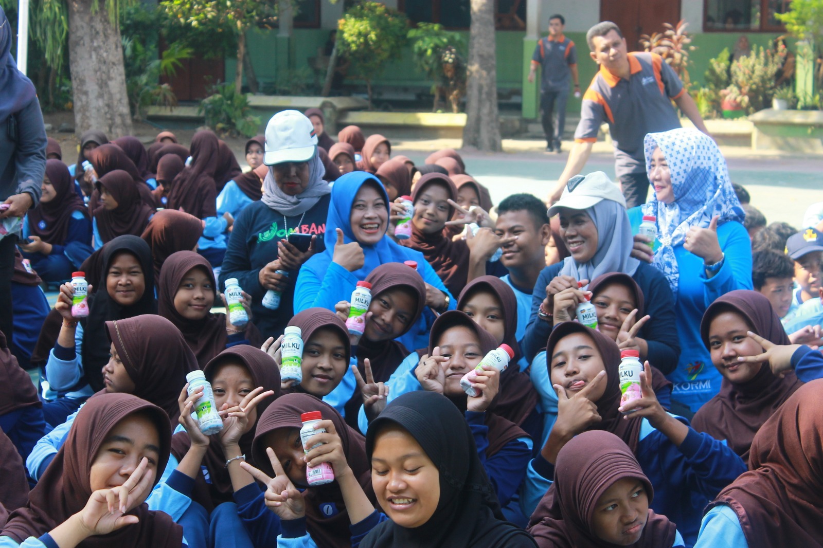 Foto: Wiwin Sumrambah, S.Pt. bersama siswa SMPN 1 Mojoagung saat minum susu bersama dalam program sosialisasi SKJ Jadul dan Senam Poco - poco Nusantara KORMI Jombang.