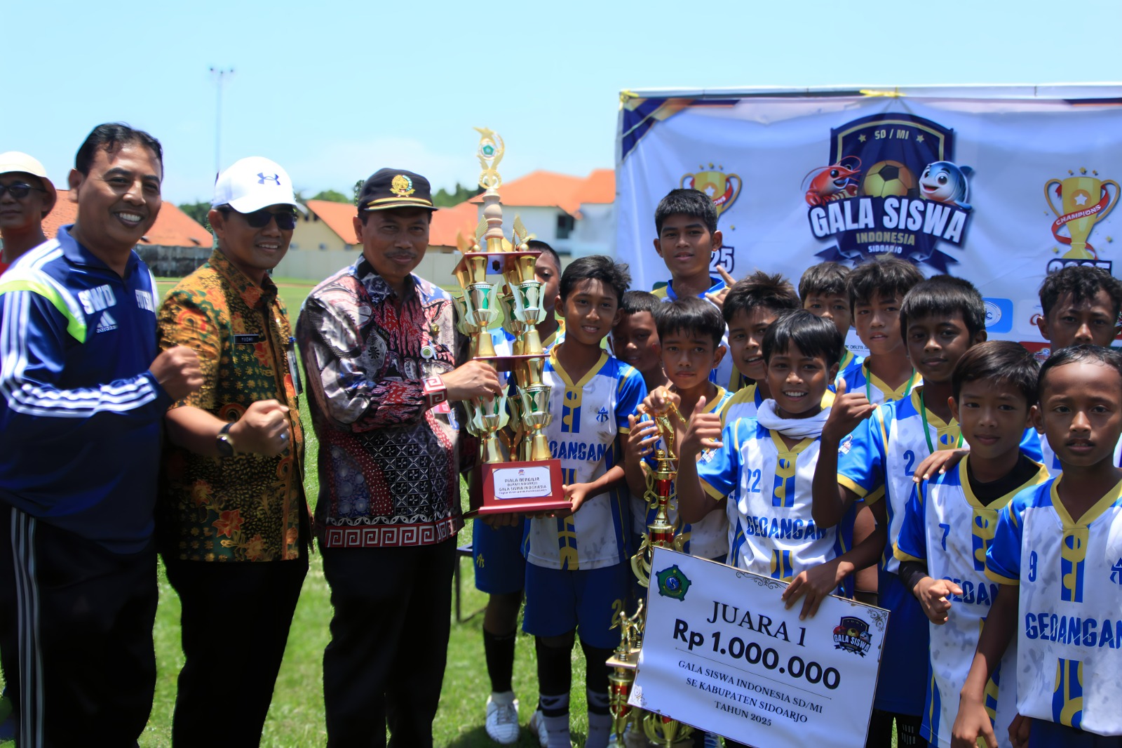 Foto: Kadisdikbud Sidoarjo Dr. Tirto Adi, M.Pd saat meyerahkan piala kepada Kecamatan Gedangan didampingi Kadispora dan Kepala Sekolah.